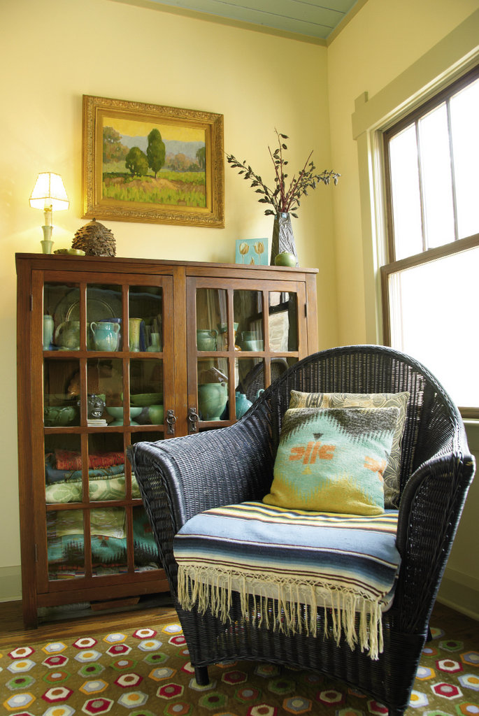 In the office, an arts-and-crafts bookshelf holds colorful vintage blankets made at the former Beacon Manufacturing textile mill in Swannanoa, as well as many pieces of contemporary and vintage pottery the two have collected while exploring mountain towns. The painting by Stuart Roper is titled Junipers at Dawn. Wool rug by Wisteria.
