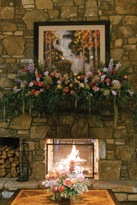 A crackling fireplace becomes the room focus with a medley of gorgeous florals adorning the mantel.