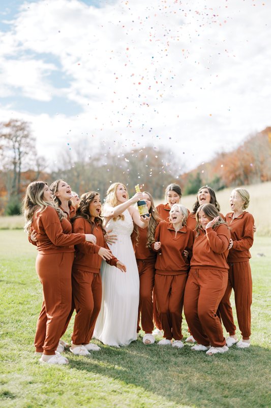 The bride with her besties dressed in matching rust-colored jammies.