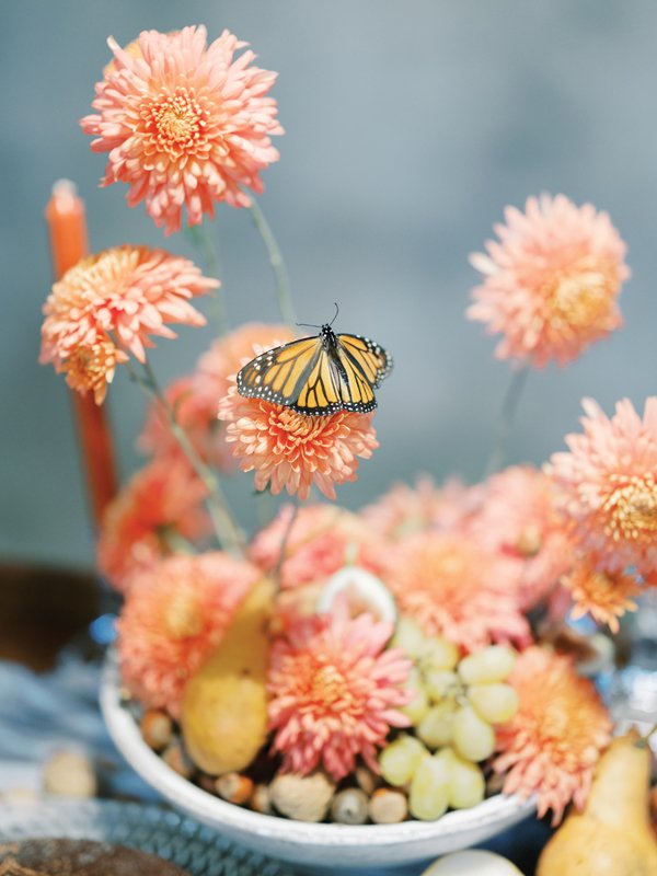 Floral arrangements with monarchs and fruit give a touch of whimsy.