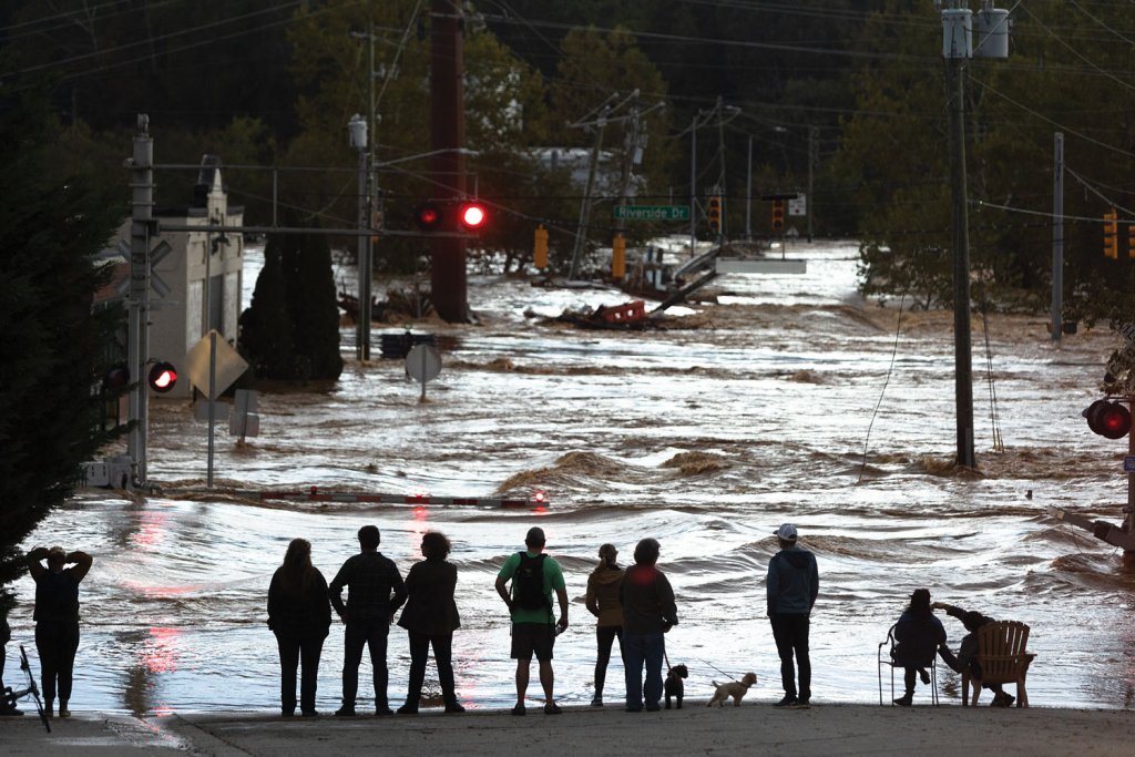Onlookers stand at the edge of the flooding in the River Arts District.