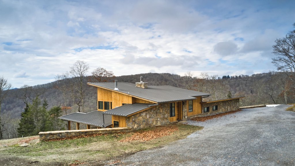 High ceilings and handpicked modern furnishings complete the rustic industrial style that the homeowners were going for. The exterior of the home features hemlock wood siding and stone accents.