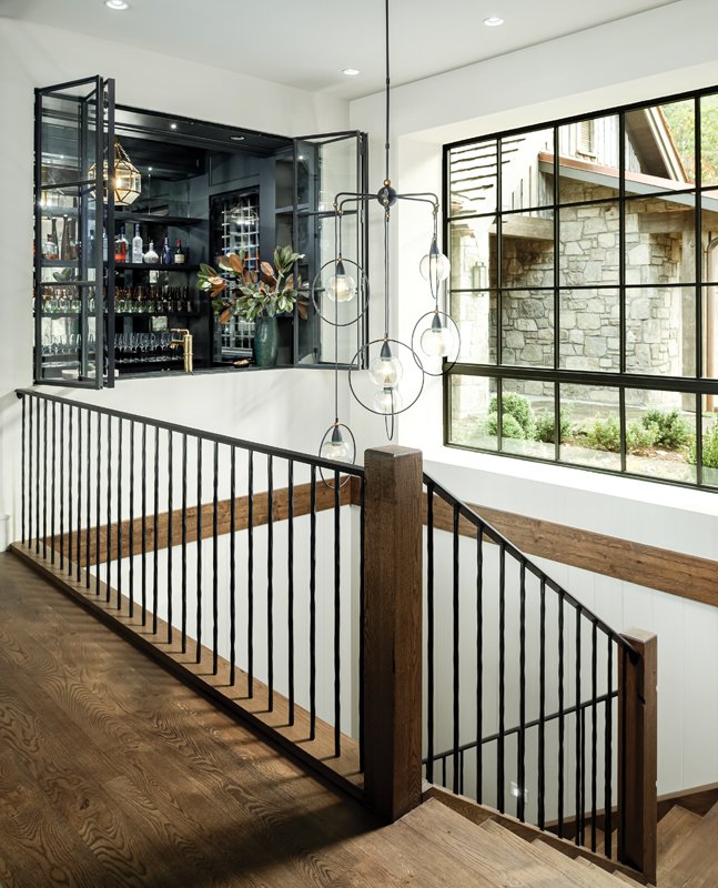 A window from the bar area opens up above the staircase, which perpetuates the home’s open-air feel.  The large window above the staircase lets the daylight pour down to the lower levels of the home.