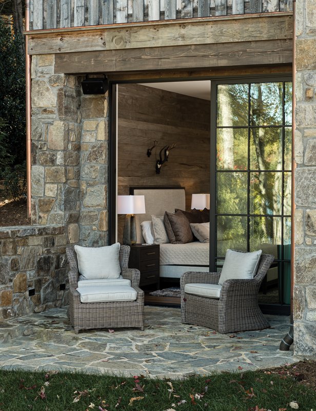 Sitting above the covered storage dock is a patio with a dining table and lounge chairs.