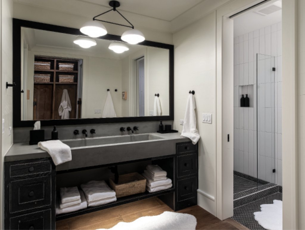 The adjoining bathroom includes a concrete double sink and private toilets and showers off to both the left and right. “Our children are grown, so I wanted the room to be comfortable but not look like a kid’s rumpus room,” says Maribeth.