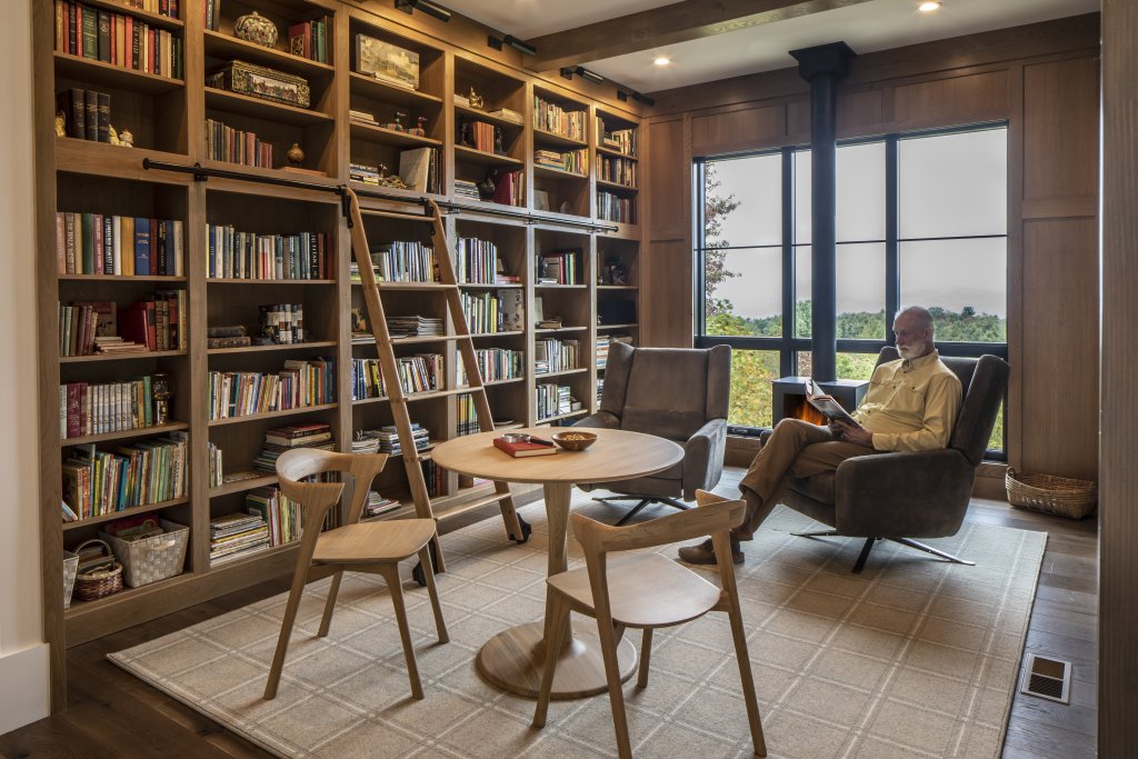 Wooden wonders - The library’s modern furnishings, including a study table with matching chairs and nearby swivel accent seating, create a soothing, earthy atmosphere that houses the Williams’s literary collection.