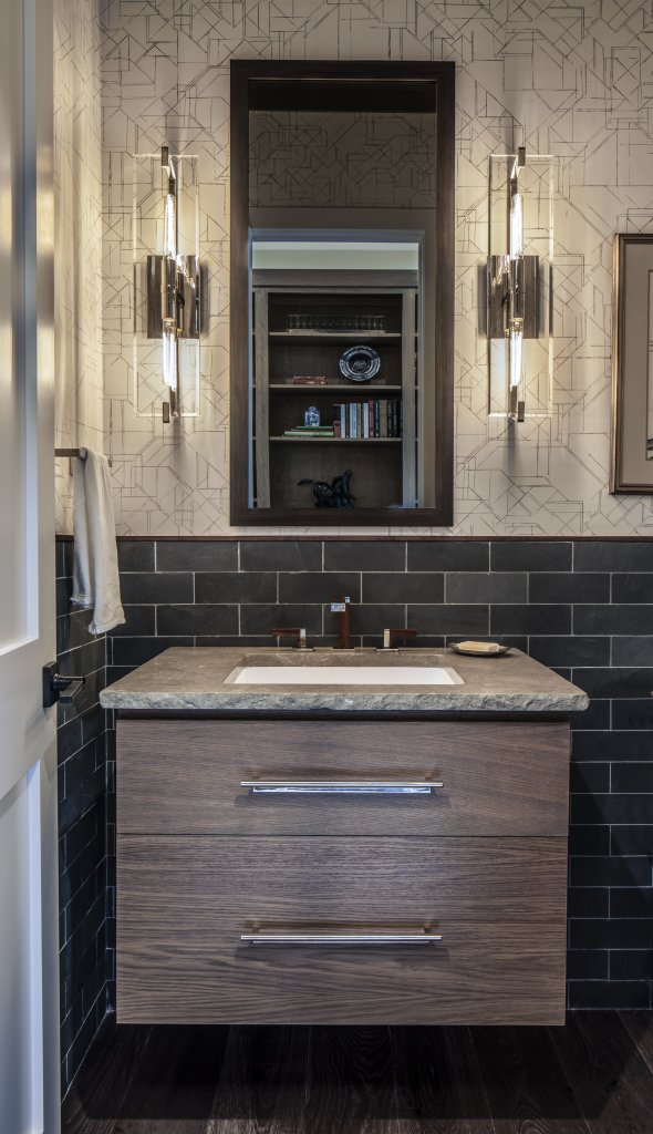 In a nearby bathroom, darker shades of wood and tile contrast the main living space’s lighter wood grains.