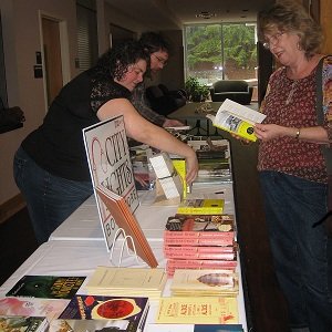 Attendees browse the City Lights Bookstore&#039;s table.