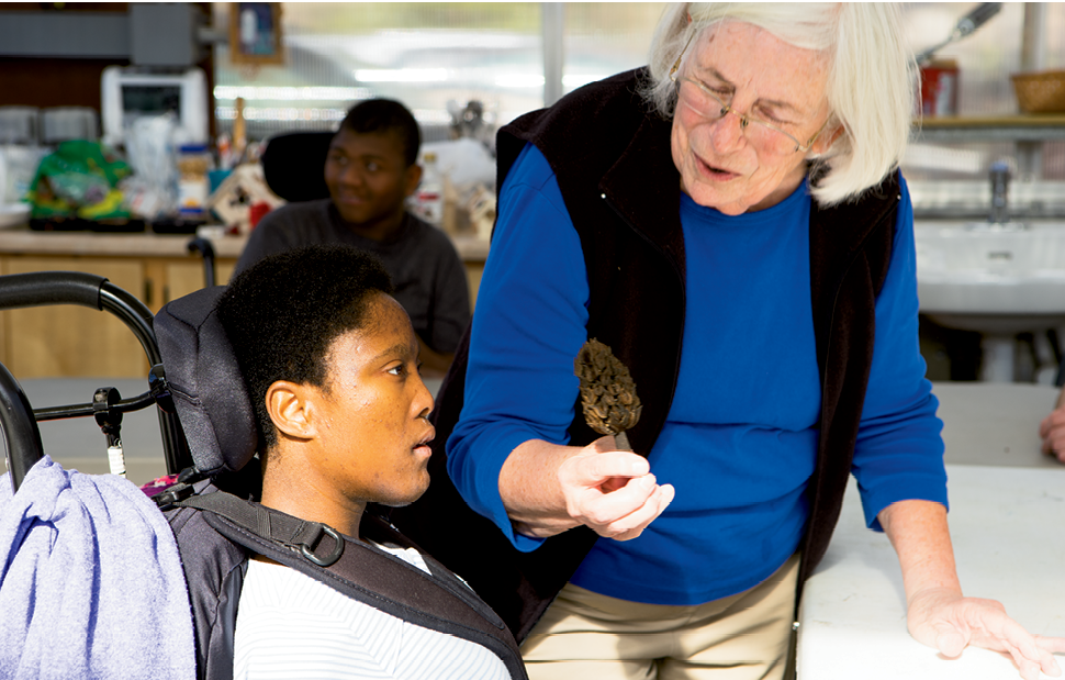 Connecting to Nature - Retired special  education teacher Mary Hugenschmidt shows a seedpod to Terriona Dula. The program exposes participants to the natural world.