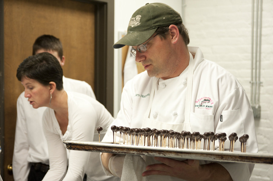 Chef Charles Hudson holding a pan of his chocolate-covered blueberries.