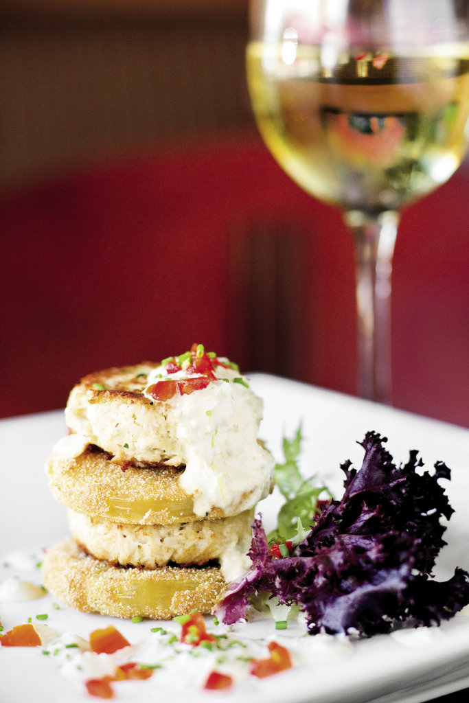an appetizer of Maryland-style lump crab cakes layered between fried green tomatoes served with a rémoulade.