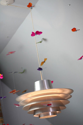 The midcentury fixture about the ship ladder came from Ginger&#039;s parents. Paper butterflies add whimsy to the room.