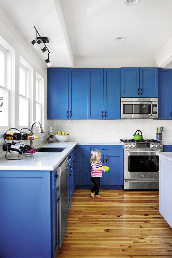 The Palmes opened up the kitchen by removing walls between it and the dining room and adding windows. Clean white tiles against sharp blue cabinets further brighten the space.