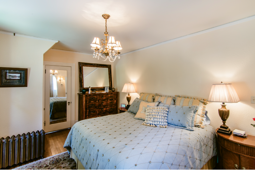 In the master bedroom, one of the windows had been obscured with shelves. The renovation involved restoring the windows, repairing and painting the stucco walls, and refurbishing all the light fixtures.