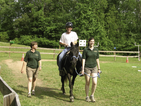 Jonah Sabo takes Allen around the paddock at FENCE with assistance from volunteers Carson Kay and Emily Kay.