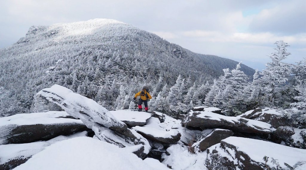 Winter camper Drew Clancy gingerly crosses crags on the Grandfather Trail below Calloway Peak. Visit our website to follow Clancy on his journey, to learn more about winter weather on Mount Mitchell, and to learn about cross-country skiing on Roan Mountain.