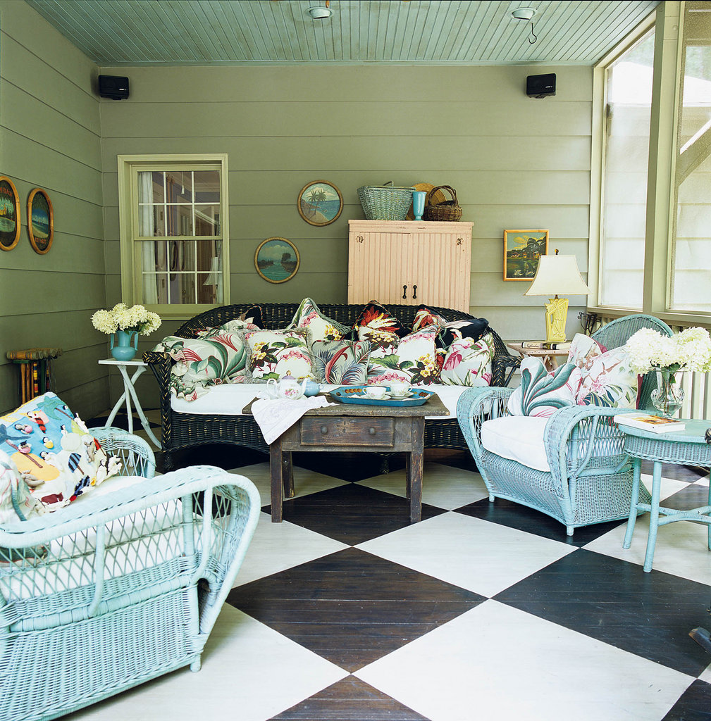 Squared Away: On the screened porch, a pair of chairs from the 1940s are outfitted with plump down cushions made from circa-1920 bedspreads and pillows fashioned from bark cloth remnants. Stained and painted oak flooring forms an oversized checkerboard pattern. “I was always very conscious of how everything