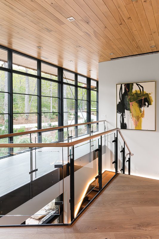 Designed not to feel like a typical enclosed basement, three out of four of the lower-level walls are fully glass, letting in an uphill view of the property.