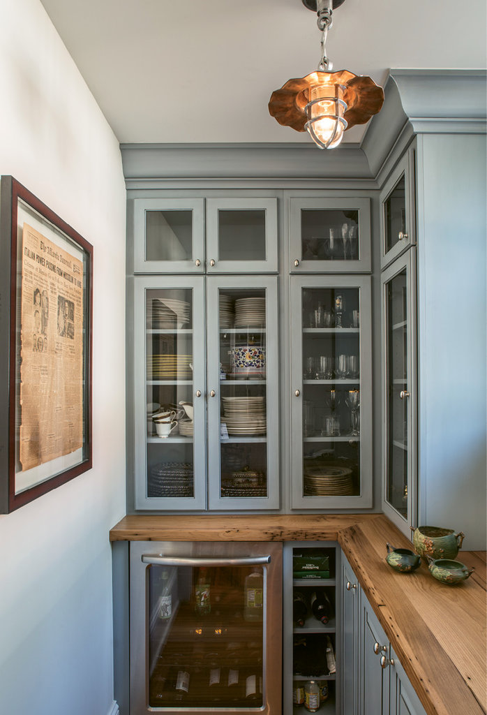A small pantry holds servingware, while framed on the wall is a little piece of the house: a newspaper from 1929 that was found in the wall during renovations.