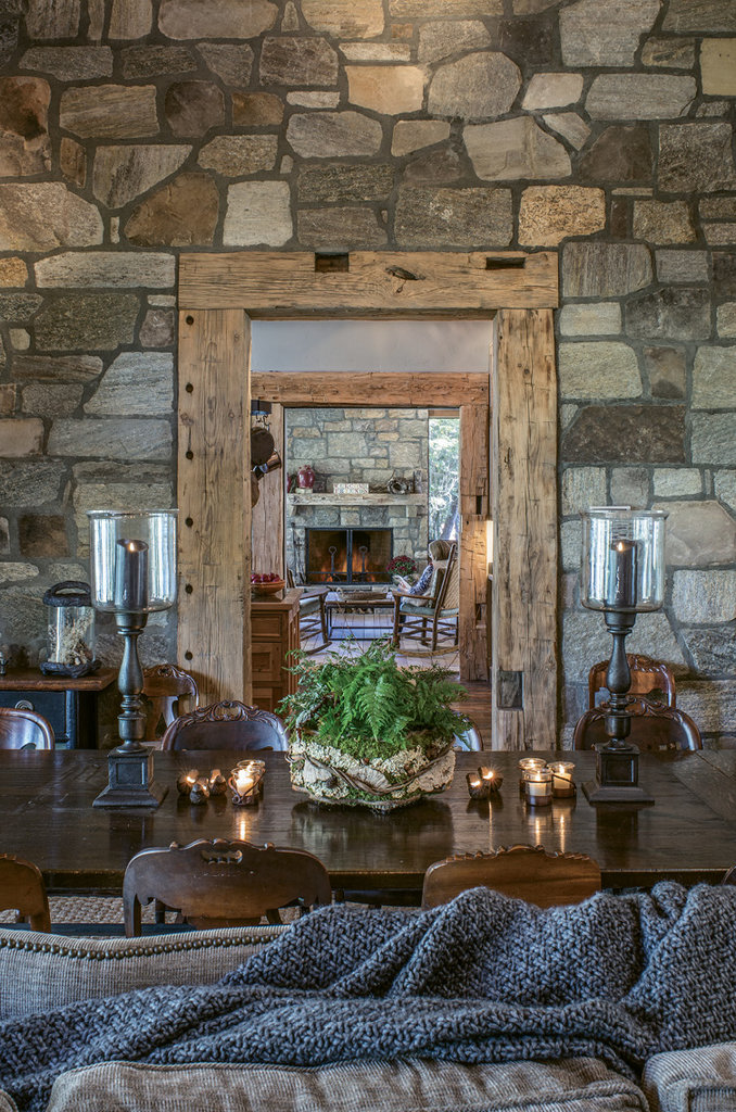 A stone wall in the living room (looking toward the kitchen) is made to appear as if it were once on the home’s exterior.