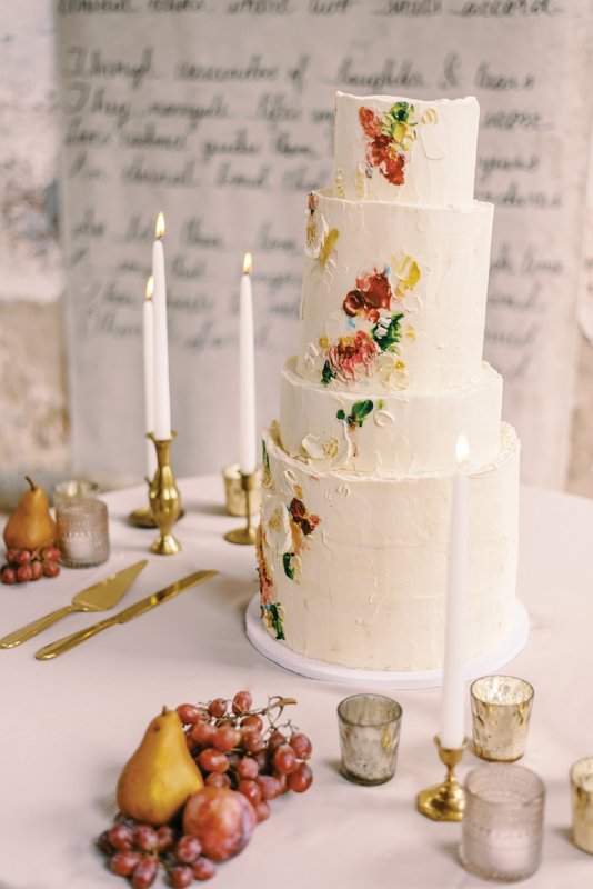 A four-tiered cake featuring traditional wedding cake with almond buttercream, London Fog (chocolate with earl grey buttercream), and pumpkin with molasses buttercream.