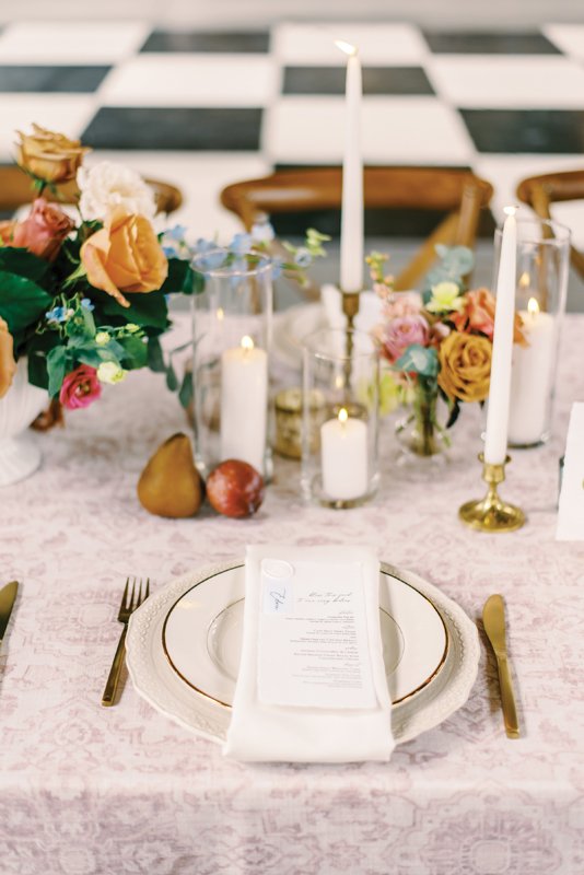 A romantic tablescape adorned with ripened pears, brass candlesticks and garden roses lend an antique appeal.