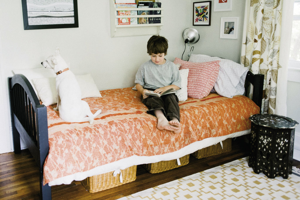 Noah enjoys a book with Luna in his bedroom, where a mix of colors and patterns makes for a lively space.
