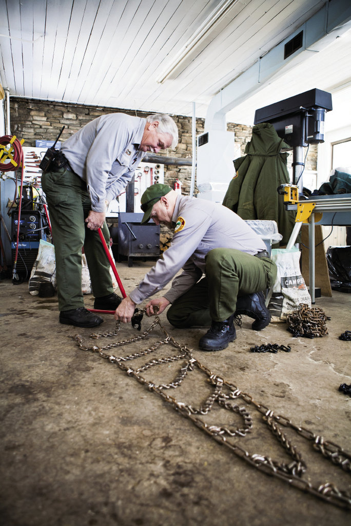 Larry Blevins and Wade Barnett repair tire chains that keep park vehicles from sliding on the road.