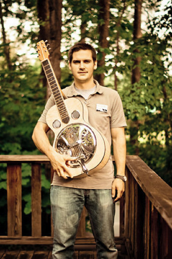 Folk School staff member Reed Caldwell with the resonator guitar he made in a class at the Brasstown campus.