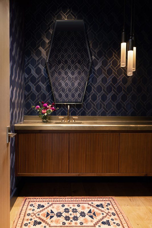 Both the downstairs and upper powder rooms feature Phillip Jeffries wallpaper and vintage rugs from Togar.