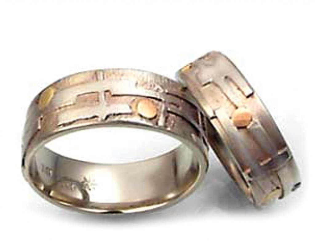 Sealed with a Kiss - White Gold Echo Wedding Bands. 14 karat white gold band with 8 karat green and rose gold accents. $1,785, men’s band, $1,560 women’s band. Vrooman Designs, Asheville. vroomandesigns.com