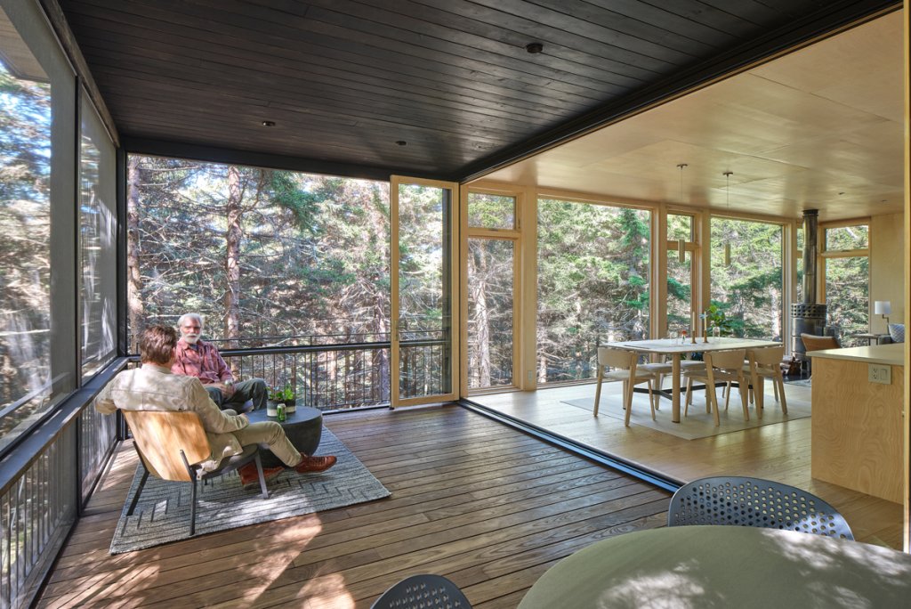 In Tune - Porches provide a segue into the scenic views surrounding a home. With a screened space connecting to the kitchen, function meets distinction in a way that&#039;s lasting for homeowners. Natural finishes tie each sectioned space together.