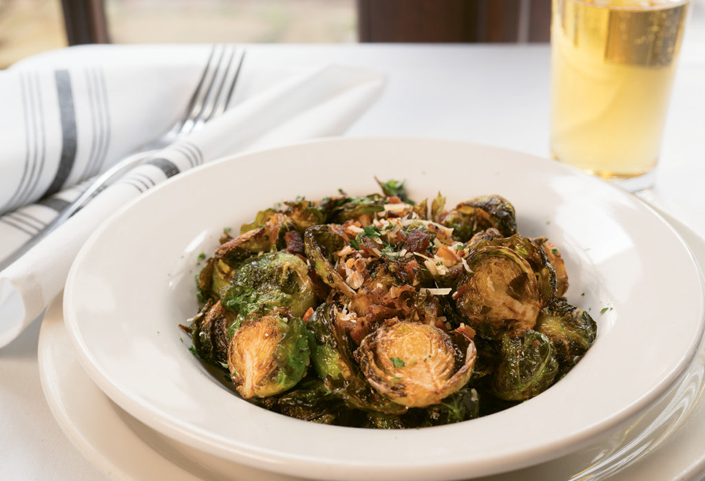 Southern Comfort Crispy Brussels sprouts are savory with bits of maple-peppered bacon, Parmesan cheese, and pickled cherry peppers.