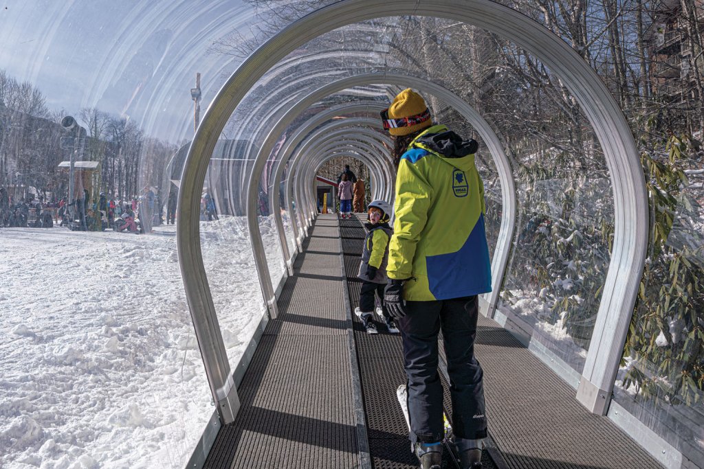 A covered magic carpet lift protects a Sugar Mountain ski instructor and student. Courtesy of Cataloochie Ski Area.