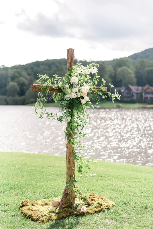 A rugged cross adorned in swaths of green and ivory.