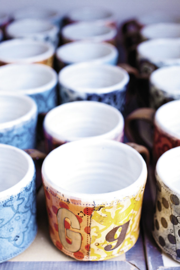 Colorful screen-printed mugs on the way to the kiln.