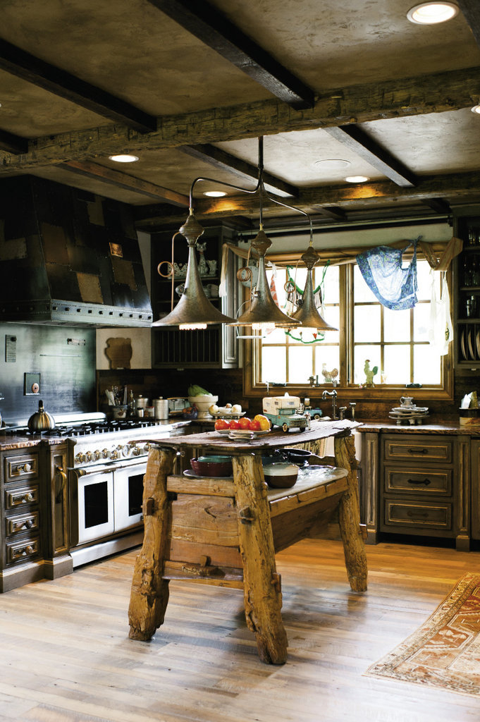 The island anchoring the kitchen, which features custom cabinetry and metal work, was assembled by affixing an old outhouse door