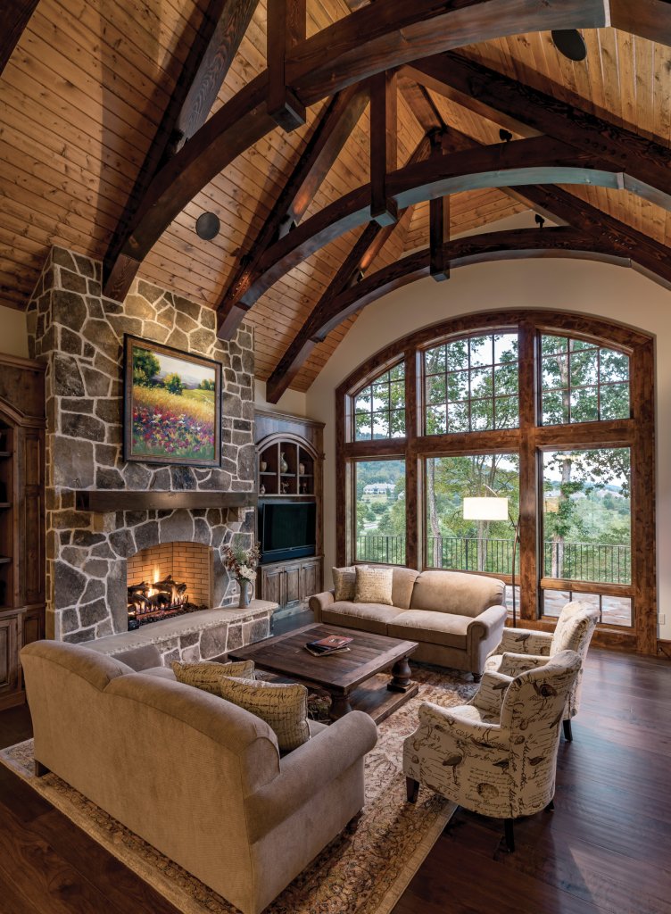Rustic Luxe - In the great room, arched ceiling trusses against a light-stained pine vaulted ceiling lend dramatic effect that rivals the inviting fireplace and views out the oversized window. The kitchen, which features ample custom cabinetry, a large polished granite-top island, and leathered granite countertops elsewhere, is an attractive space for entertaining.