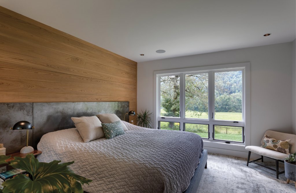 Bedroom Oasis - The Witherspoon’s home is filled with ties to the land. Accenting the master bedroom, the wood-paneled wall bridges the thousands of trees that cover the property with the interior space. In the bathroom, stone and wood finish adorn the fixtures.