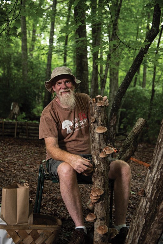 Greg Carter with a mushroom log, an efficient and safer way to grow and eat fresh mushrooms.