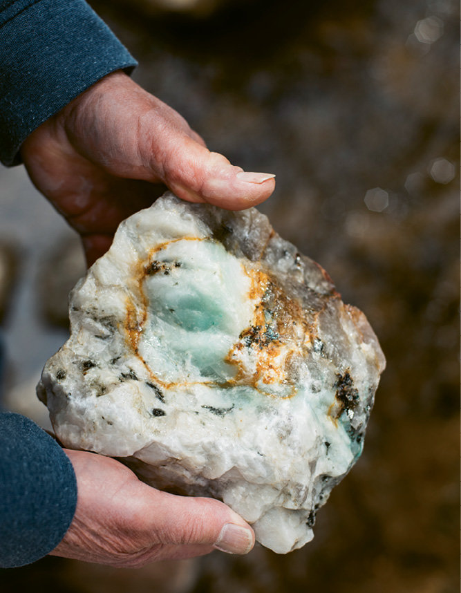 This pegmatite, estimated to be 380 million years old, contains feldspar (the white), blue-green malachite, shiny black mica, and brown streaks indicating uranium ore.