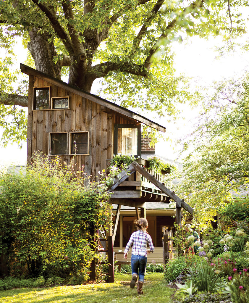 An adorable eight-by-eight-foot, two-story tree house, complete with a sitting room and sleeping loft, towers over the Thomases’ lush backyard garden in West Asheville.
