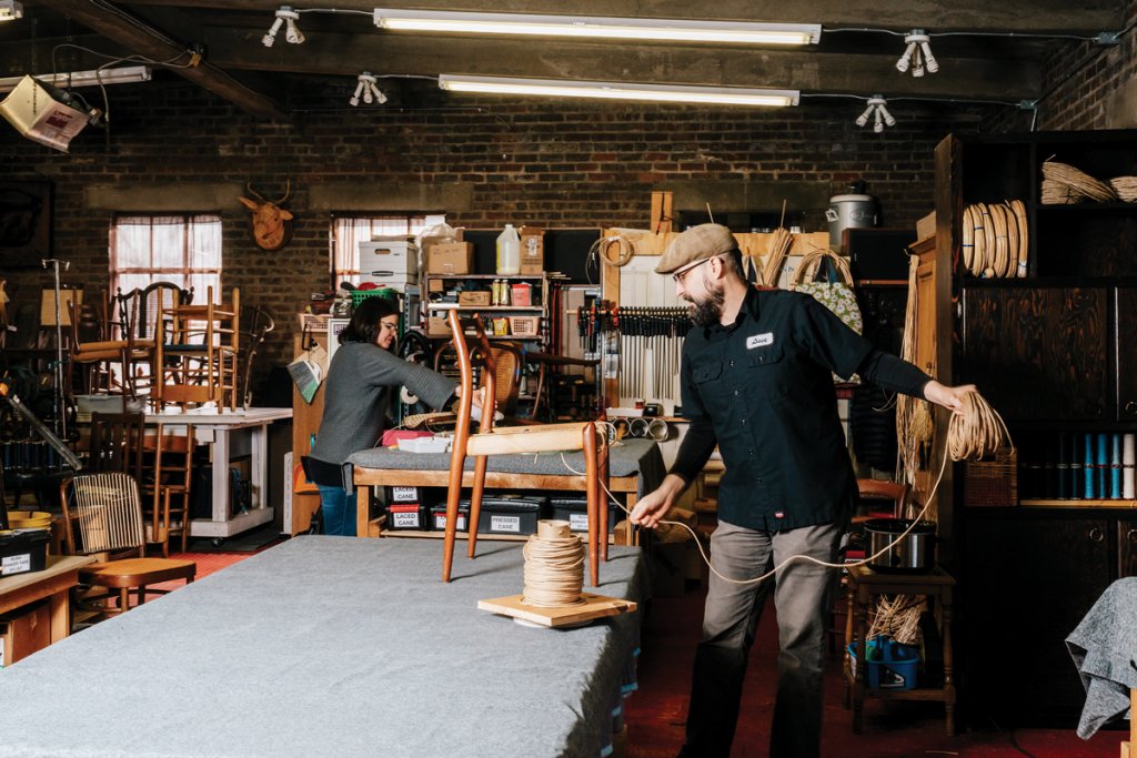 The Asheville workspace is filled with tools, materials, and historic ephemera.