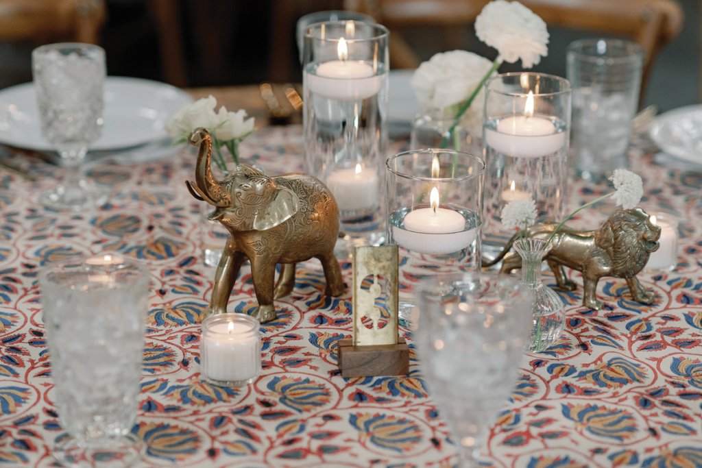 Self-dubbed “treasure hunters,” Chesnut and Will scoured thrift shops for brass collectible to decorate the tables along with cut glass goblets and floating candles.