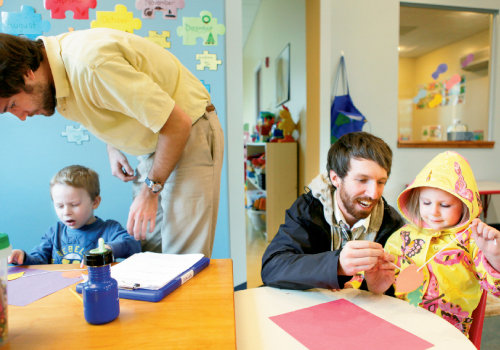 Behavioral therapists Cliff Cowan (left) and Andrew Buchanan work with children during an art session. The kids are constantly engaged in monitored  activities and ABA therapy.