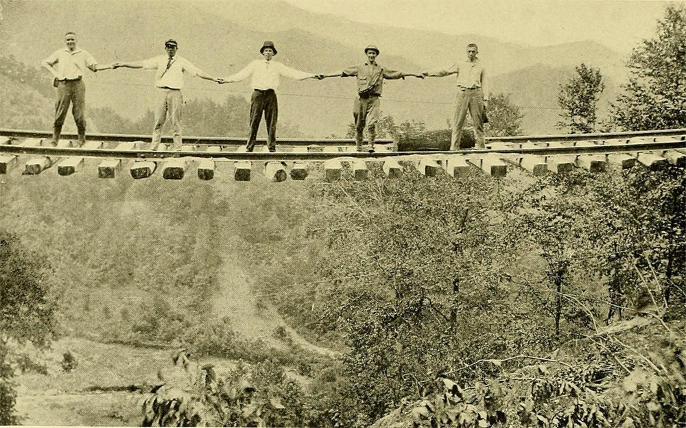 Railway workers braved a portion of track between Old Fort and Ridgecrest, where the earthen support had been completely washed out.