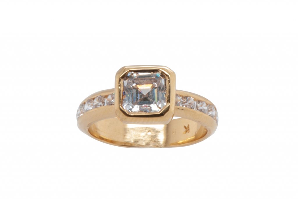 A Cut Above Asscher - Cut Bezel Set Ring. 7mm center stone with ten round cut accent stones. Customizable gem options, available in a white or yellow metal. $3,250+. Katherine Alexander Fine Jewelry, Asheville. katherinealexanderfinejewelry.com